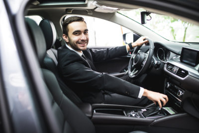 young man in suit driving car